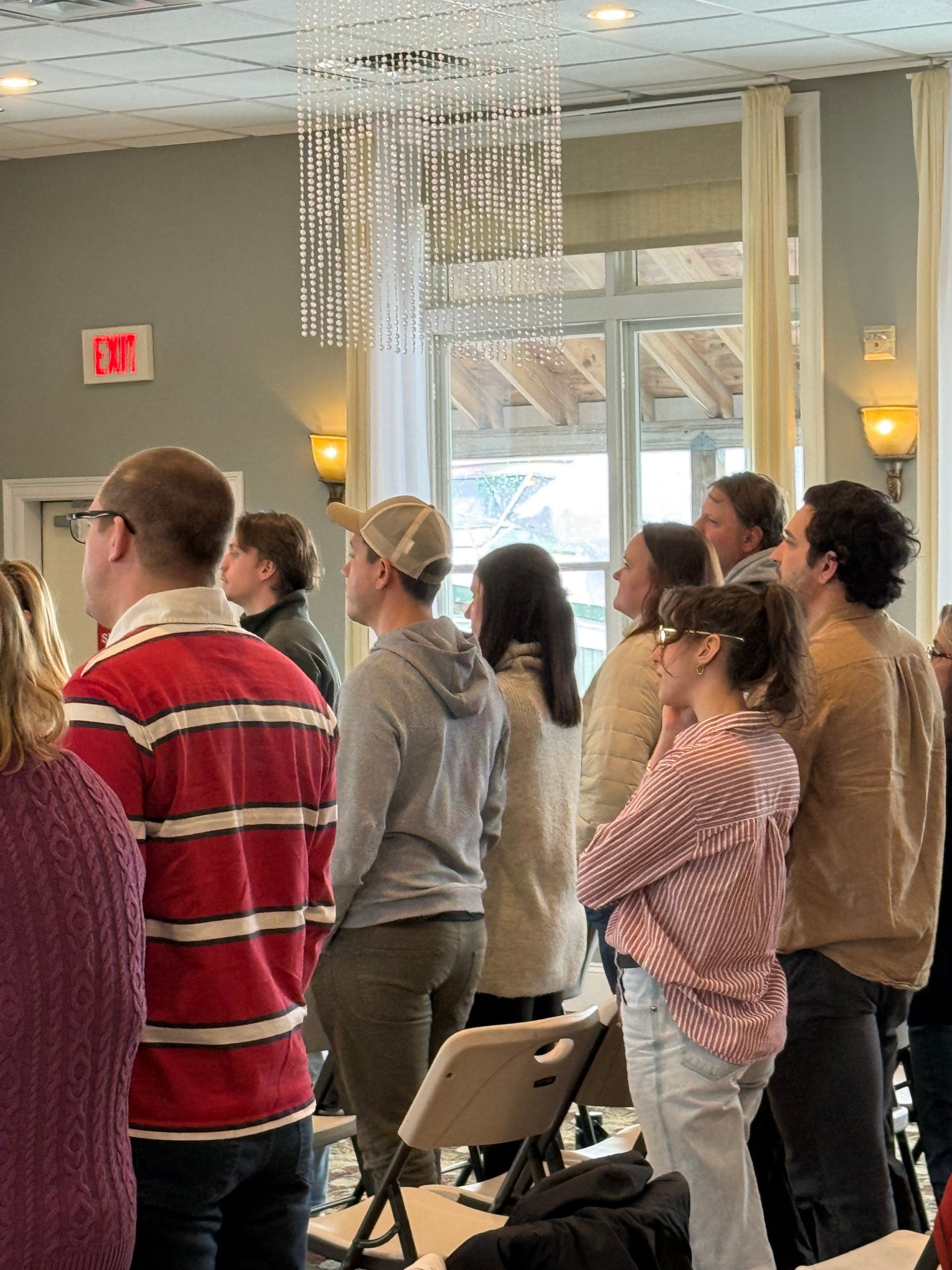 People in casual clothes standing during a Sunday service